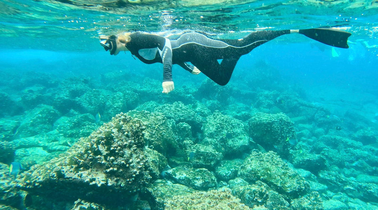 Swimming above a sunlit reef in clear ocean water